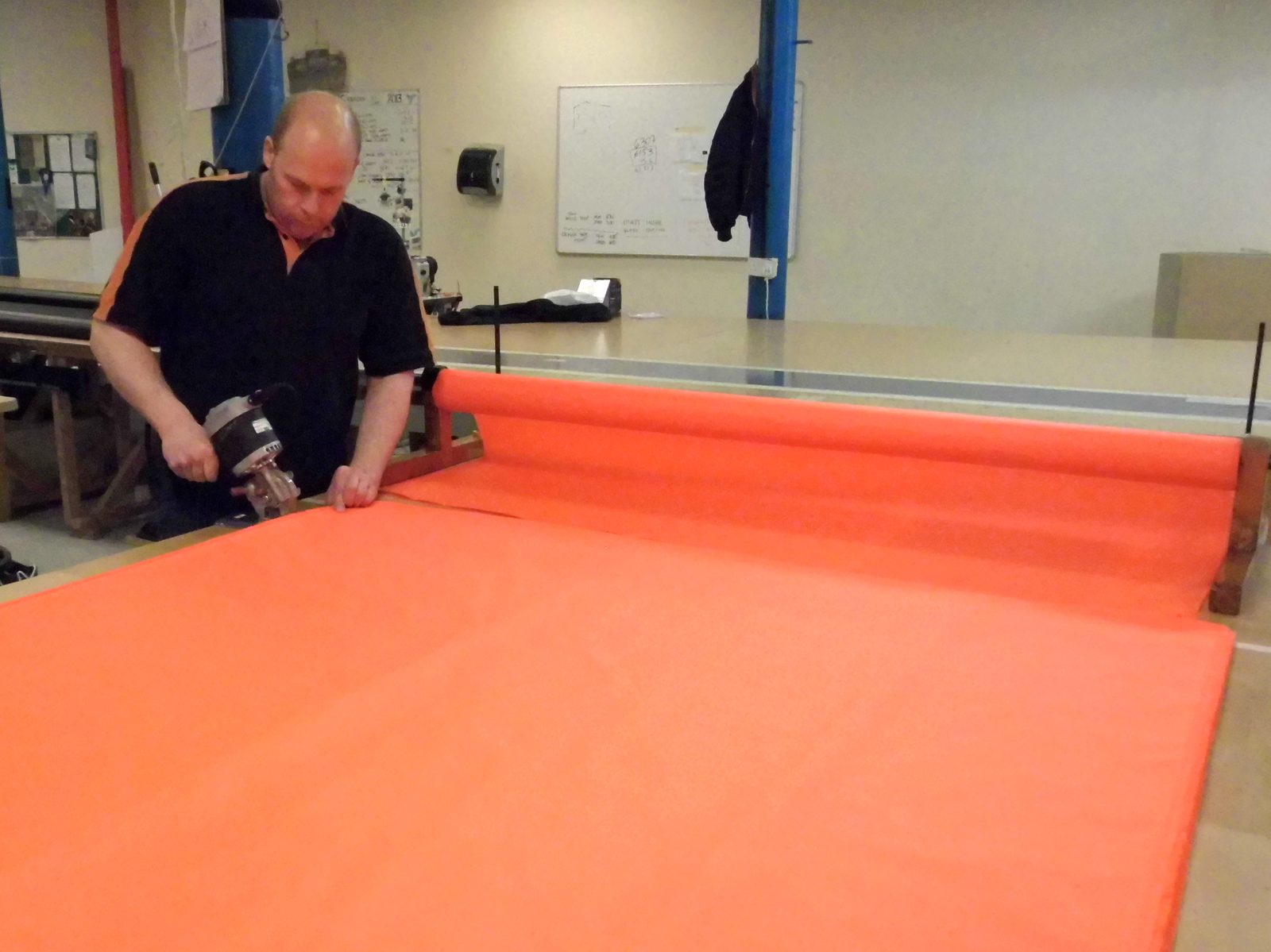Fabric being cut to panel size on the workshop bench